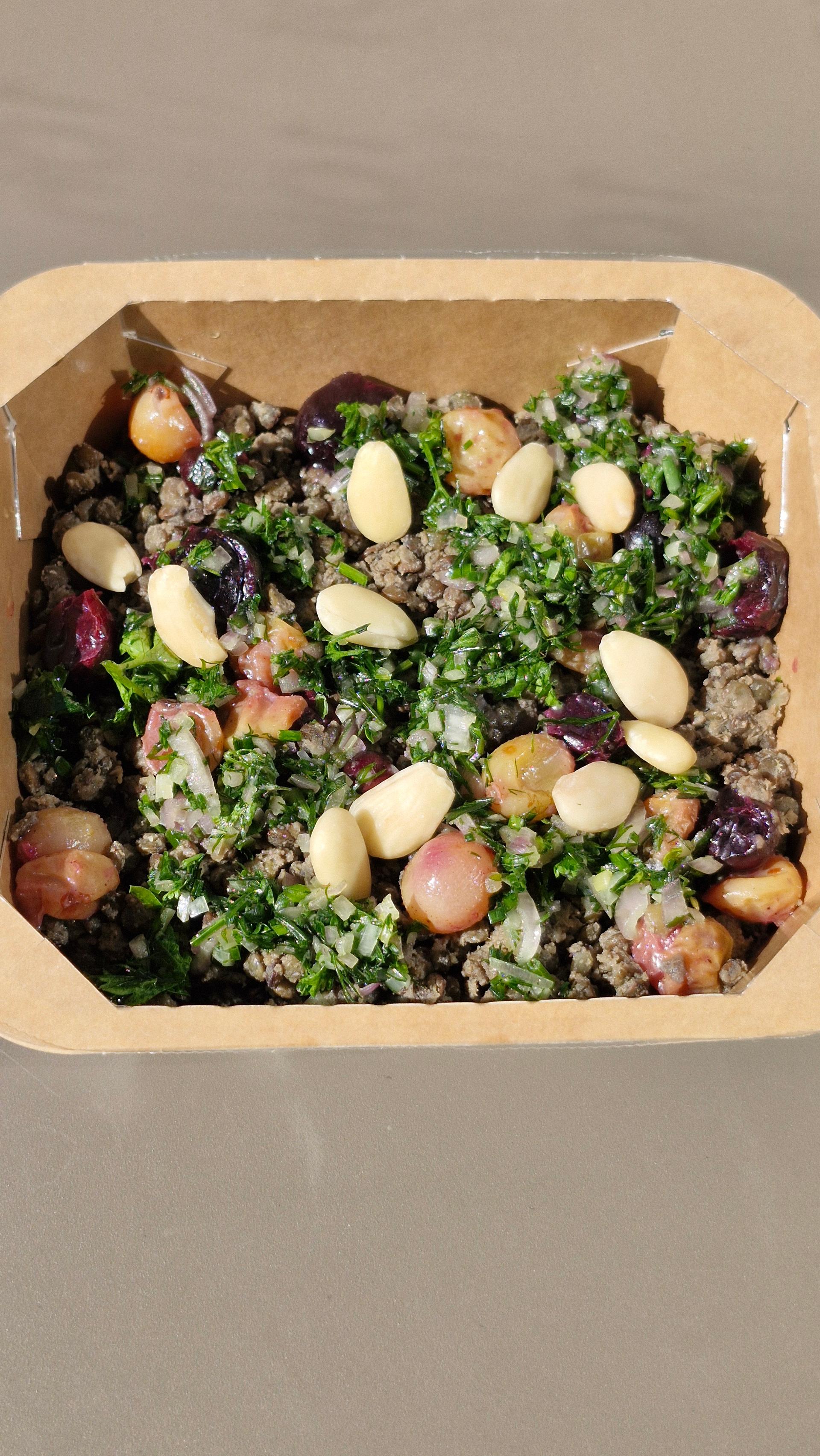 Lentilles crémeuses au cumin, raisins rôtis, amandes et condiment aux herbes fraîches