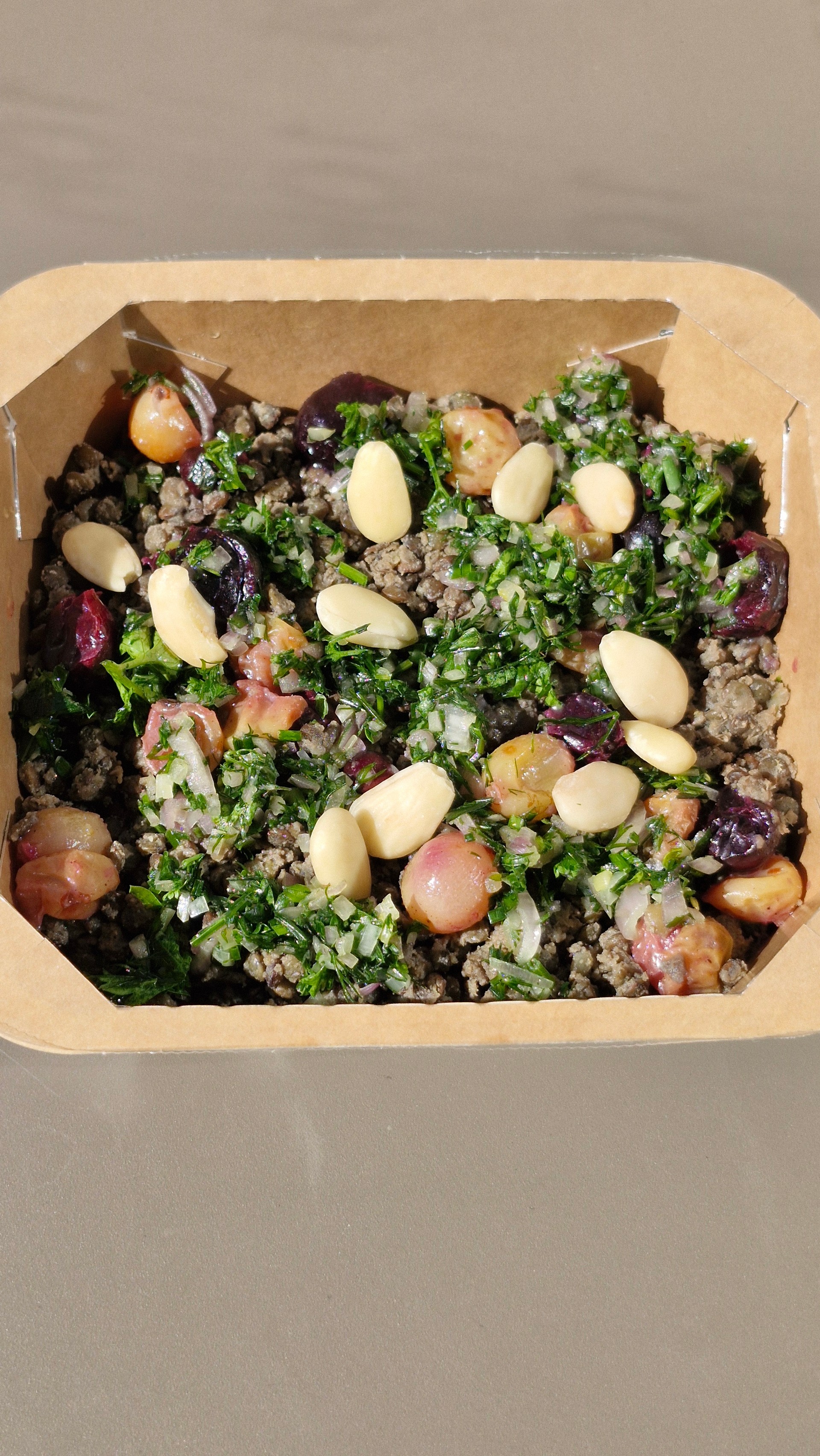 Lentilles crémeuses au cumin, raisins rôtis, amandes et condiment aux herbes fraîches